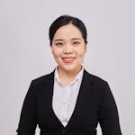 Businesswoman in a suit smiling confidently, ideal for corporate themes.